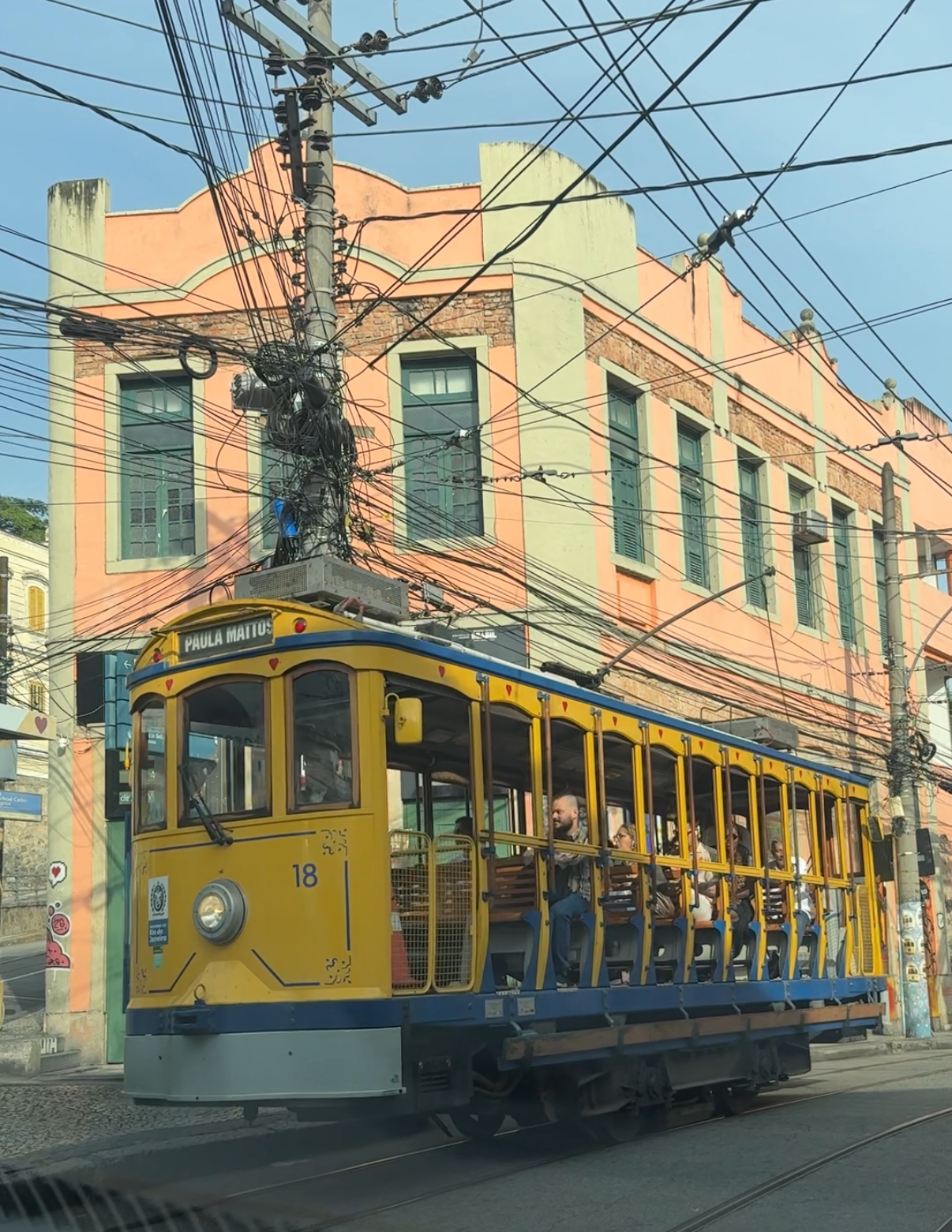 Bondinho jaune de Santa Teresa (ligne Paula Mattos) devant une façade coloniale orange à Rio de Janeiro